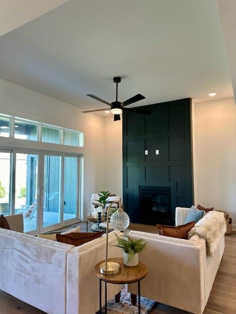 living area featuring ceiling fan, recessed lighting, wood finished floors, and a fireplace