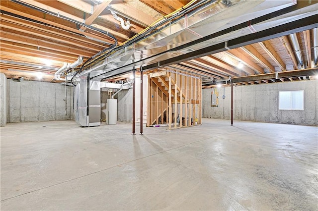 unfinished basement featuring heating unit and water heater