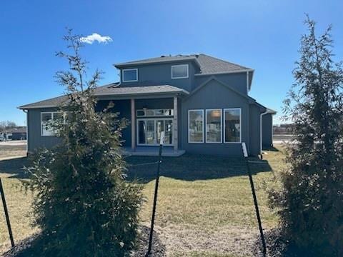 rear view of property featuring a yard