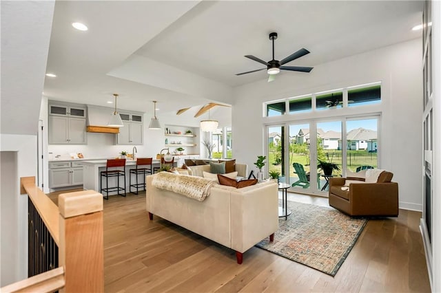 living room with recessed lighting, light wood-type flooring, and ceiling fan