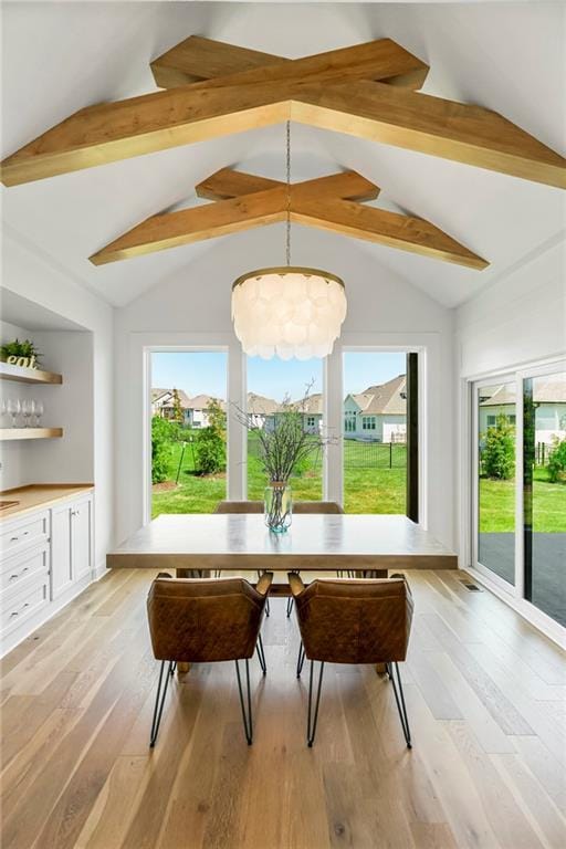 sunroom / solarium featuring vaulted ceiling with beams