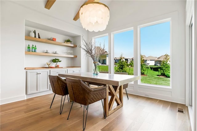 dining room featuring a wealth of natural light, visible vents, and light wood-style flooring