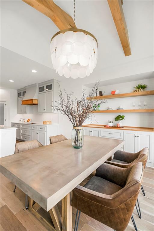 dining room with an inviting chandelier, beam ceiling, recessed lighting, and light wood-style floors