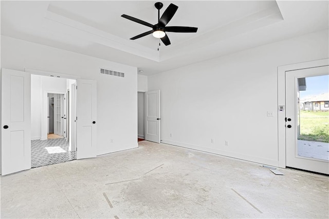 unfurnished bedroom with a ceiling fan, baseboards, visible vents, a raised ceiling, and access to outside