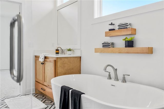 bathroom with a soaking tub and vanity