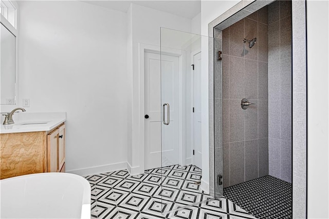 bathroom featuring vanity, a freestanding tub, baseboards, and a stall shower