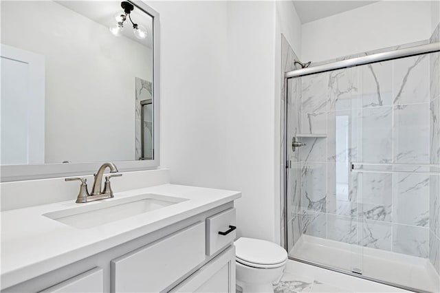 full bath featuring a marble finish shower, marble finish floor, toilet, and vanity