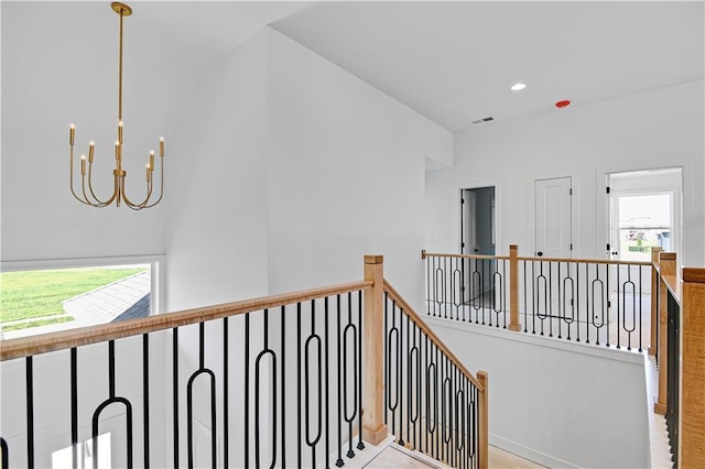 stairway with recessed lighting and an inviting chandelier