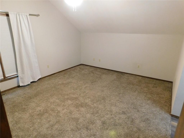 bonus room with lofted ceiling and carpet