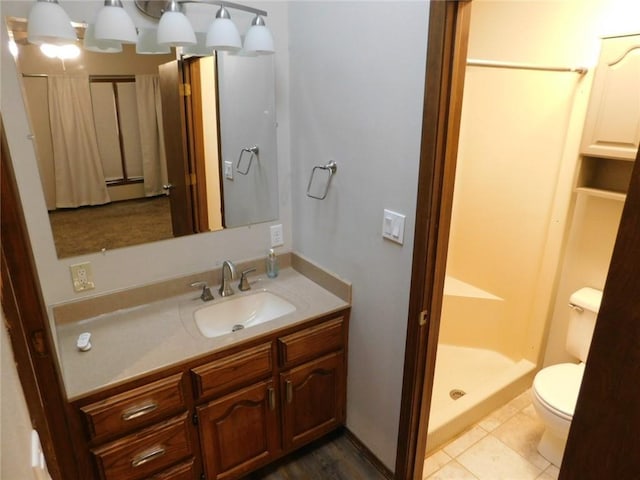 bathroom featuring vanity, toilet, tile patterned floors, and walk in shower