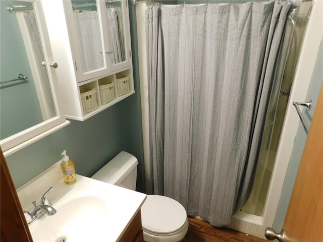 bathroom featuring hardwood / wood-style flooring, toilet, vanity, and a shower with shower curtain