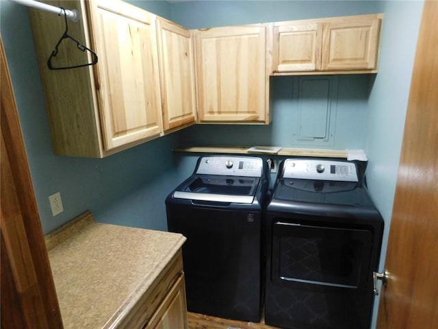 laundry room featuring washer and clothes dryer and cabinets