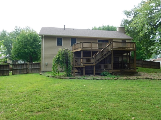 rear view of property with a wooden deck and a yard