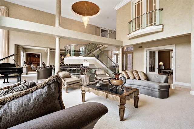 living room with crown molding, decorative columns, stairway, a high ceiling, and carpet flooring