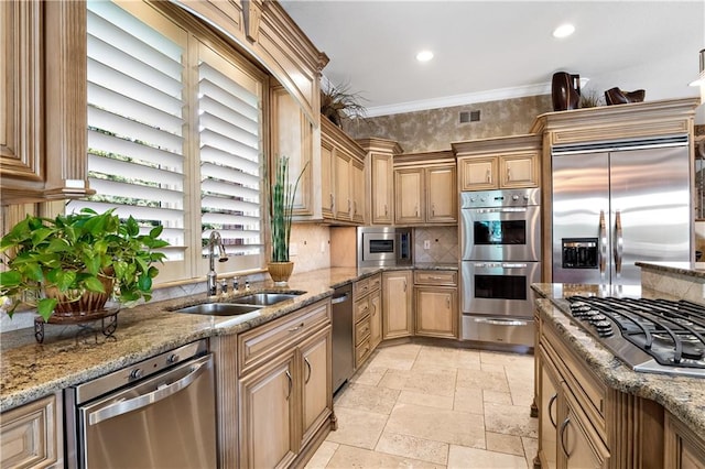 kitchen featuring built in appliances, stone counters, crown molding, sink, and light tile patterned floors