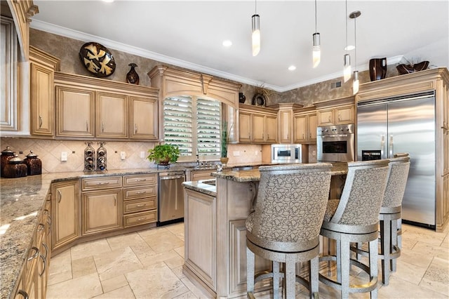 kitchen featuring a center island, light stone counters, built in appliances, a kitchen bar, and ornamental molding