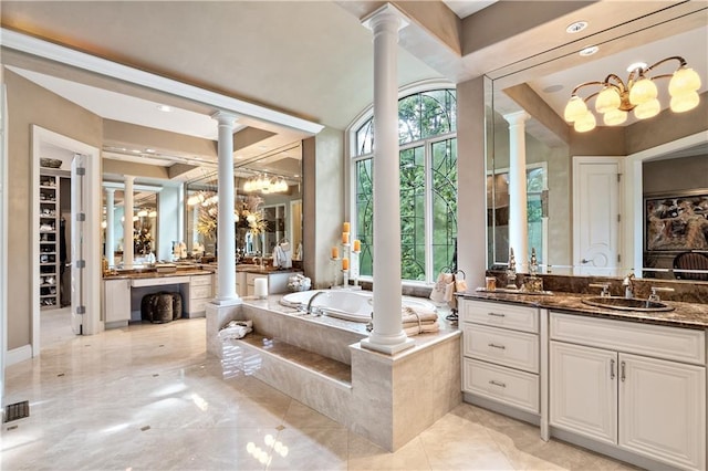 bathroom featuring decorative columns, an inviting chandelier, tiled bath, vanity, and tile patterned floors