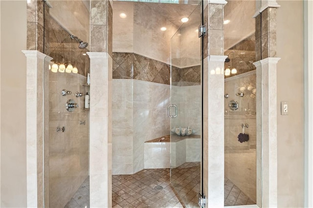 full bathroom with ornate columns and a stall shower