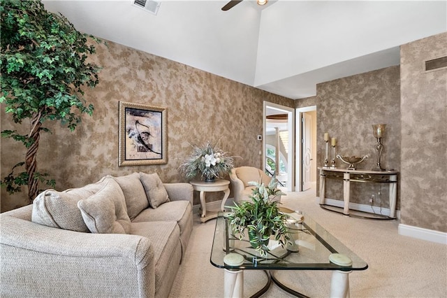 carpeted living room featuring ceiling fan and a towering ceiling