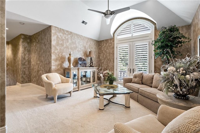 living room with carpet flooring, visible vents, vaulted ceiling, and a ceiling fan