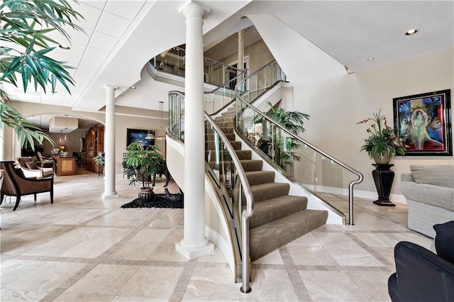 stairway featuring a wall mounted air conditioner, ornate columns, and light tile patterned floors