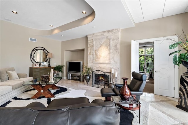 living area with marble finish floor, a fireplace, visible vents, and recessed lighting