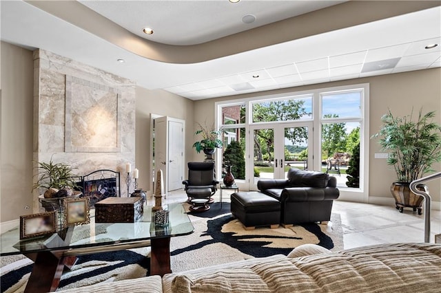 living room featuring french doors, baseboards, recessed lighting, and a high end fireplace