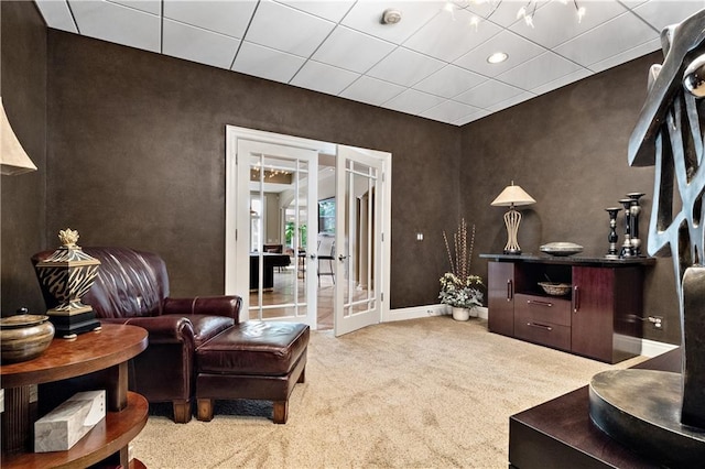 interior space with light carpet, a drop ceiling, and french doors