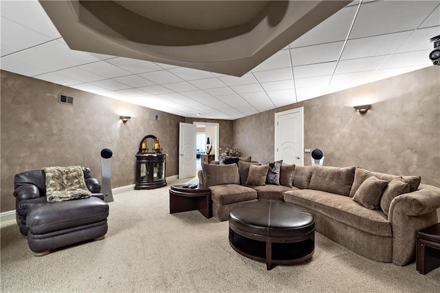 carpeted living area featuring visible vents, a drop ceiling, and baseboards