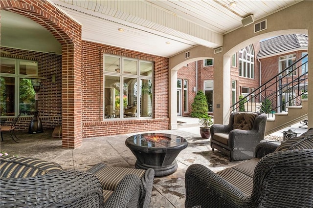 view of patio featuring an outdoor fire pit, stairway, and visible vents