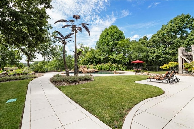 surrounding community featuring a patio, a swimming pool, and a lawn