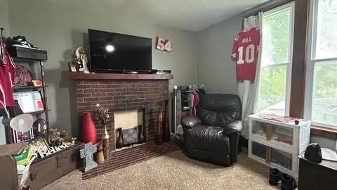 sitting room featuring carpet and a fireplace