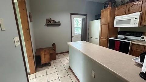 kitchen with light tile patterned flooring and white appliances