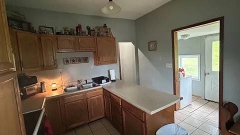 kitchen with sink, light tile patterned floors, and kitchen peninsula