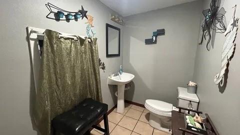 bathroom featuring tile patterned floors, toilet, and sink