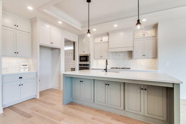 kitchen with decorative backsplash, appliances with stainless steel finishes, light hardwood / wood-style flooring, and hanging light fixtures