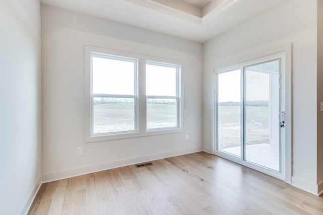 spare room with a water view and light hardwood / wood-style flooring