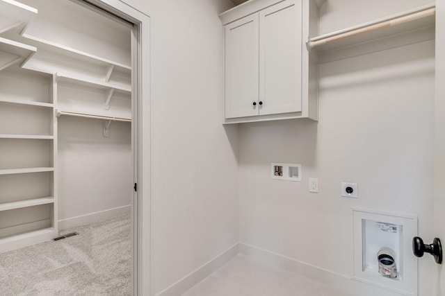 laundry room with electric dryer hookup, light carpet, hookup for a washing machine, and cabinets