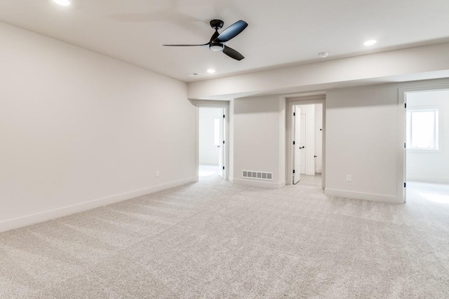 spare room featuring ceiling fan and light carpet