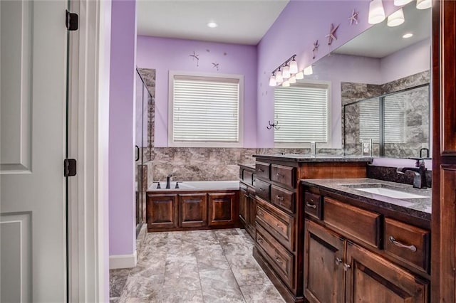 bathroom featuring vanity and independent shower and bath