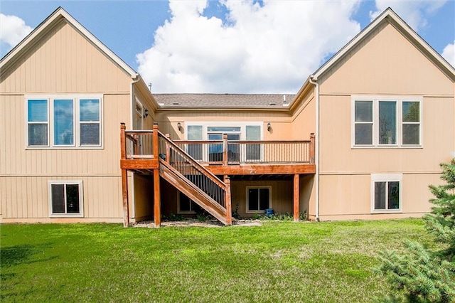 rear view of house featuring a wooden deck and a lawn