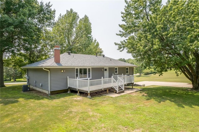 back of house with a wooden deck, a lawn, and central AC unit