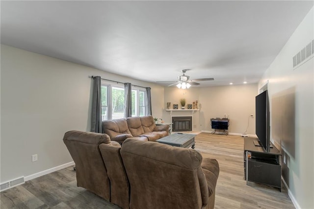 living room featuring light wood-type flooring and ceiling fan