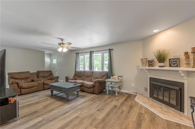 living room with light hardwood / wood-style floors and ceiling fan