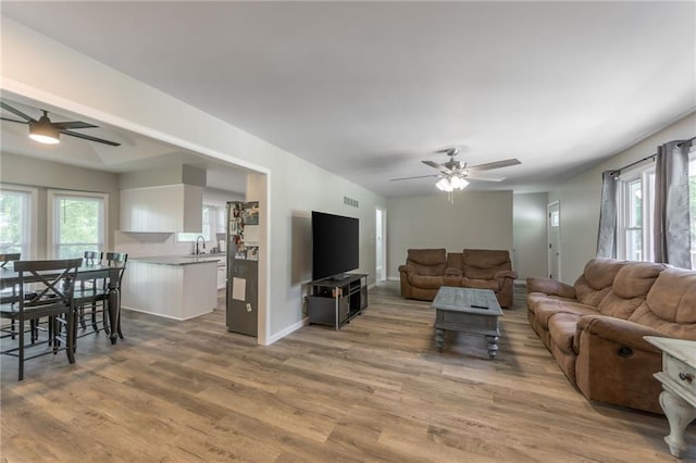 living room featuring sink, ceiling fan, and wood-type flooring