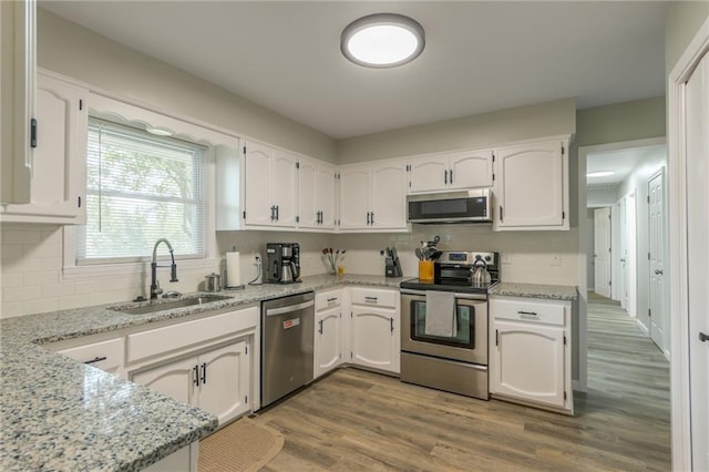 kitchen with sink, wood-type flooring, white cabinets, and stainless steel appliances