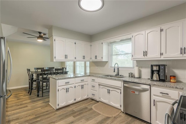 kitchen with ceiling fan, white cabinets, light wood-type flooring, sink, and appliances with stainless steel finishes