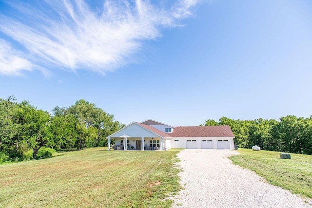 view of front facade featuring a porch, a garage, and a front lawn