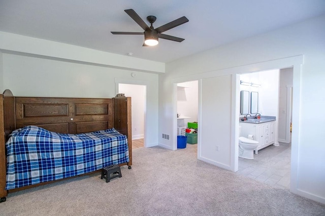 carpeted bedroom featuring ensuite bathroom, sink, and ceiling fan