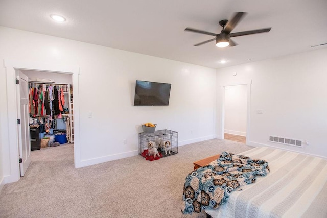 bedroom with a closet, carpet floors, ceiling fan, and a spacious closet